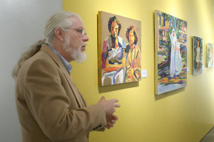  Joseph M. Bravo, Centro de Artes art administrator, explains Carolina G. Flores’ paintings of family and significant people in her life, past and present. The show, Nuestra Gente: Celebrating People Past and Present, runs Jan. 7-May 8. Photo by Paul Fernandez 