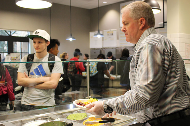 Director of Chartwells, Scott Anglesey serves A&M-San Antonio student Austin Vaiana the home-style meal of the day. Photo by Christie Tavera