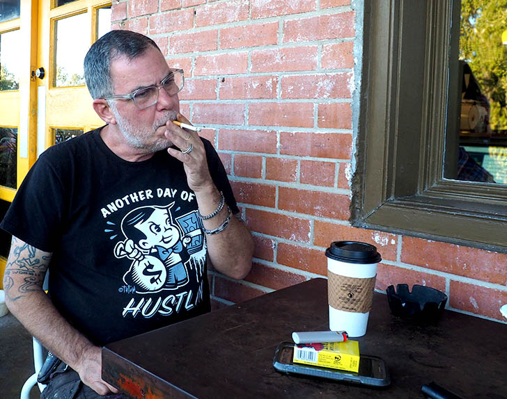Tatum takes a break from art and reorganizing his shop/studio space to grab a cup of coffee from Halycon and enjoy a cigarette. "The art is easy, it's the business part that's hard," he said.Photo by Betty Wright Rueda