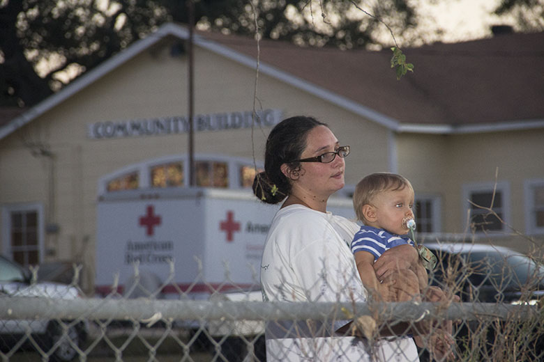 Dana Spear and son watch the scenes unfold in Sutherland Springs, TX in the wake of the deadliest mass shooting in modern Texas history, as her husband, Chris works at the 87 Ice House. Photo by James Miller