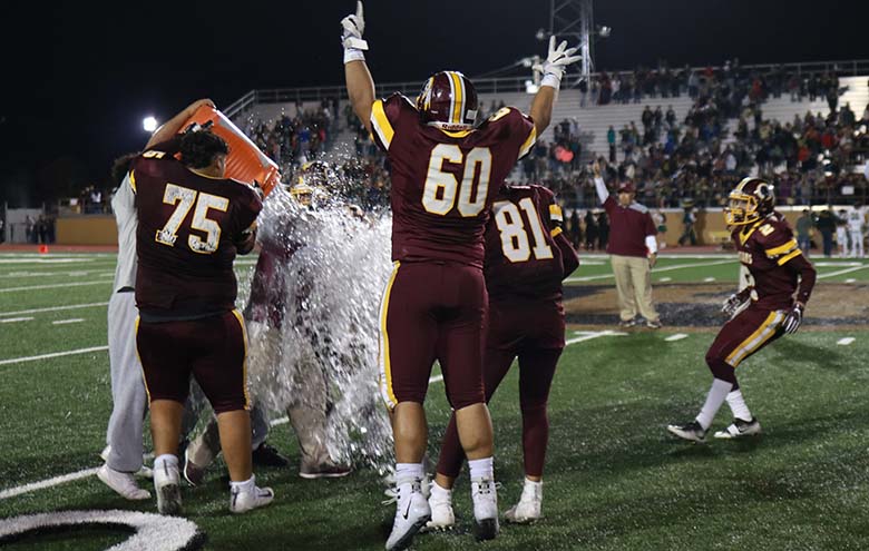 Harlandale head coach Albert Torres is doused with ice water after his team defeated the McCollum Cowboys 24-21. In his first year as coach, Torres' team came back in the last minute to steal the victory. Photo by Jose Arredondo.