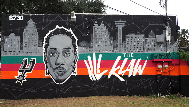 Countdown City Cuts at 6732 S Flores St, San Antonio, TX hired artist Alex James to spray-paint a colorful mural of San Antonio Spur #2, Kawhi Lenard. Photo by Valerie Lambardia 